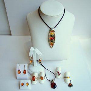 Schmuckset mit Bernsteinen in warmen Braun- und Goldtönen, bestehend aus Kette, Ringen, Anhängern und Ohrschmuck.